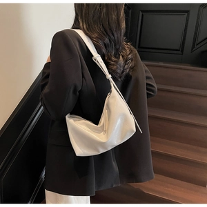 Detailed side view of off-white dumpling shoulder bag with soft pleated leather texture