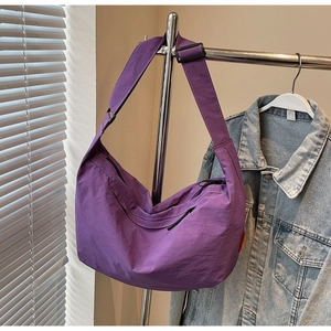 Detail of adjustable strap and purple nylon texture on the casual crossbody tote bag