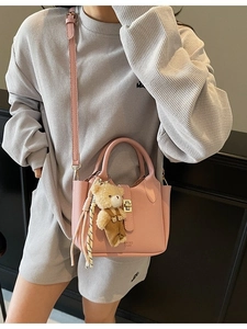 Borsa a secchiello rosa con trama litchi, ciondolo a orsetto e tracolla regolabile