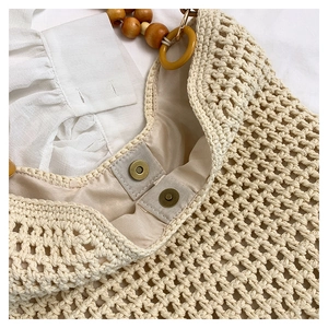 Détail du sac cabas au crochet avec perles en bois et anneau en résine jaune sur l'anse