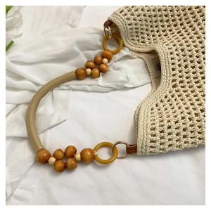Détail du sac de plage tissé montrant perles en bois, anneaux et boucles dorées