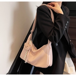 Detail of light pink large capacity tote bag with cute bear charm worn by a model