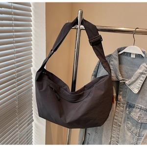 Detail view of large charcoal crossbody crescent bag with adjustable wide shoulder strap