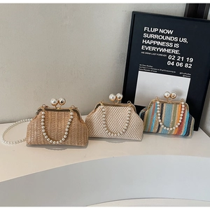 Detail view of woven straw evening bags with pearl handles and pearl clasp closures