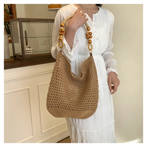 Détail d'un sac cabas tissé main avec perles en bois et texture crochet bohème
