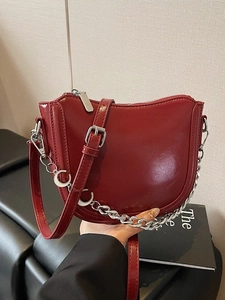 Red glossy patent leather crescent shoulder bag with chain and moon pendant detail