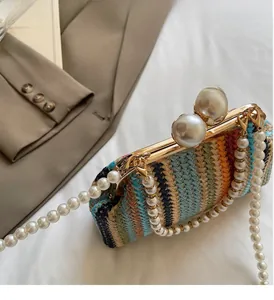 Detail of colorful woven handbag featuring large pearl clasps and pearl chain strap