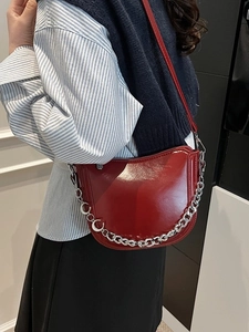 Dark red patent leather saddle bag with silver moon chain and glossy mirror finish