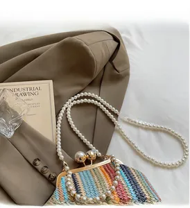 Detail of colorful woven straw bag with pearl strap and elegant metal clasp closure