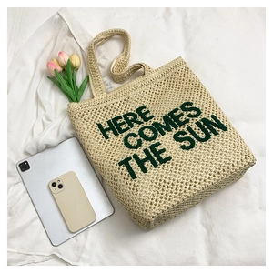 Detailed embroidery design Here Comes The Sun on a beige woven summer tote bag