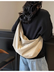 Lightweight khaki nylon tote bag with large capacity shown on a model for casual daily use