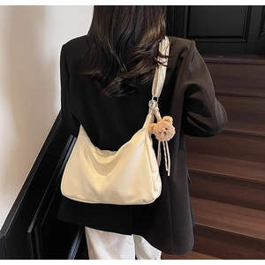 Creamy white leather underarm bag with cute brown bear charm detail on wide strap