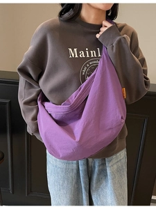 Minimalist purple canvas crescent tote bag with orange label tag for daily casual wear