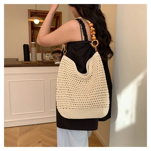 Détail du sac fourre-tout crème tissé avec sangles en perles de bois et design en maille