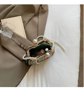 Detail of colorful woven straw bag with pearl handle and marble clasp closure