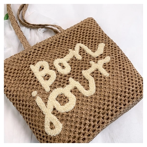 Dettaglio borsa tote in paglia marrone con ricamo Bon Jour 3D e trama intrecciata