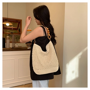 Détail du sac à bandoulière en crochet fait main avec des perles en bois sur la sangle