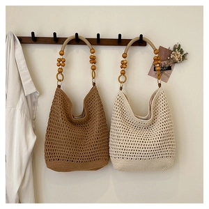 Détail de sacs de plage tissés avec anses en perles de bois et maille ajourée