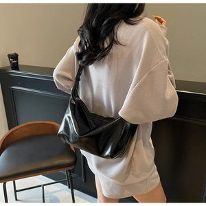 Close-up of a glossy black patent leather Hobo bag with spacious interior and soft design