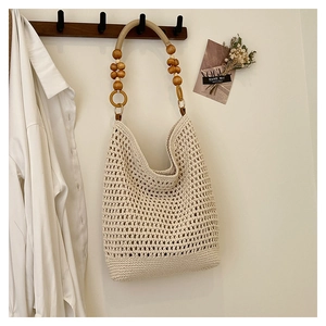 Détail du sac cabas au crochet beige avec maille ajourée et bandoulière en perles de bois