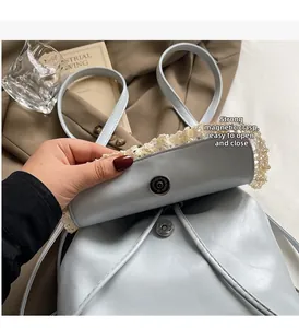 Detail of strong magnetic buckle closure on a blue leather backpack with lace trim