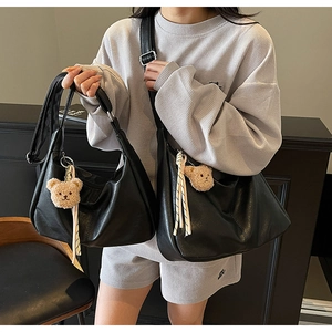 Detail showing two black soft PU leather tote bags in large and small sizes with bear charms