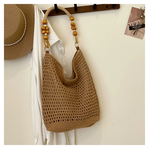 Détail d'un sac cabas marron tissé à la main avec bandoulières uniques en perles de bois