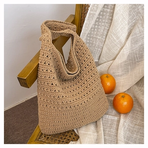 Dettaglio della borsa tote in filo di cotone intrecciato a mano su una sedia vintage