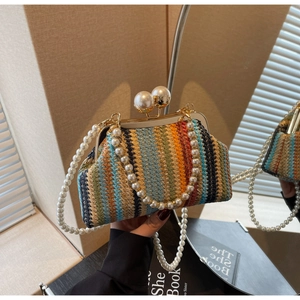 Detail of colorful woven kiss-lock bag with large pearl clasp and pearl strap