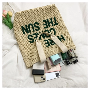 Top view of embroidered straw beach bag showing large capacity with daily essentials