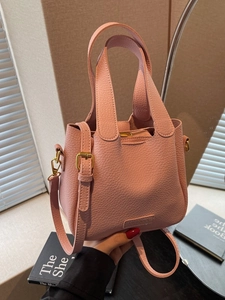 Pink lychee grain leather bucket bag with top handles and adjustable shoulder strap