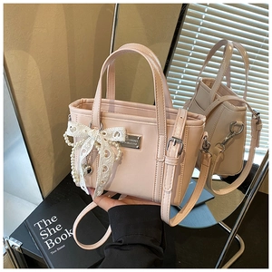 Nahaufnahme der rosa Beuteltasche mit weißer Spitzenschleife und Perlenanhänger