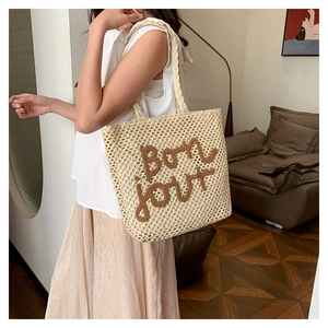 Dettaglio borsa tote tessuta a mano con ricamo Bonjour marrone e manici intrecciati