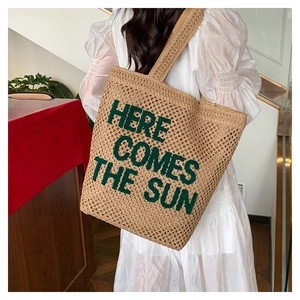 Detail of hand-woven tote bag featuring green Here Comes The Sun embroidery
