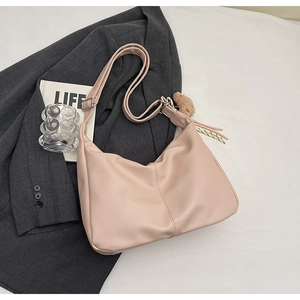 Detailed view of pink leather hobo bag with plush charm and stylish vertical stitching