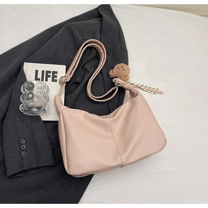 Detail of pink PU leather tote with vertical stitching and cute bear charm pendant