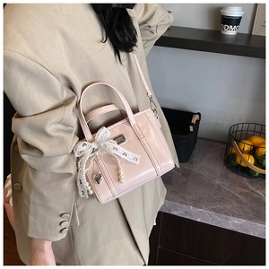 Detail der rosa Beuteltasche mit Spitzenschleife, Perlenkette und silbernem Herzanhänger