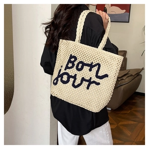 Dettaglio della borsa tote intrecciata con ricamo Bonjour e trama a rete rifinita