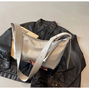 Detail of grey crossbody bag with glossy oil-wax texture and adjustable wide strap