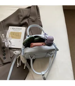 Spacious interior of light blue faux leather satchel showing phone, wallet and umbrella