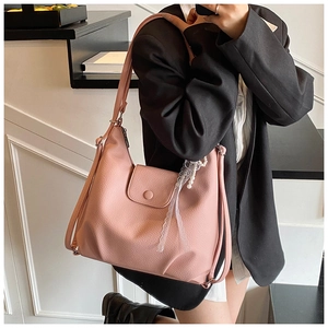 Detalle de bolso tote rosa con textura granulada y colgante de encaje con perlas