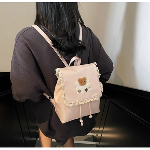 Detailed back view of pink PU leather backpack with lace trim and plush bear patch