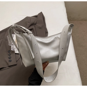 Detailed macro view of the light grey crossbody bag with adjustable strap and textured finish