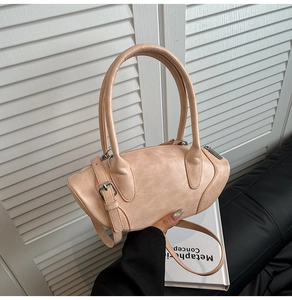 Detail of the chic beige faux leather handbag featuring a unique olive shape and slim straps