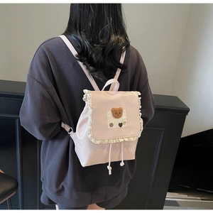 Rosa Kunstlederrucksack mit Spitzenbesatz und Plüschbär-Patch in der Rückansicht