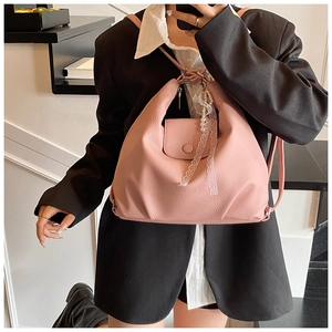 Bolso de cuero rosa con textura de lichi y colgante de perlas y encaje usado por modelo