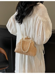 Elegant beige straw clutch bag with pearl accents and gold frame for beach vacations