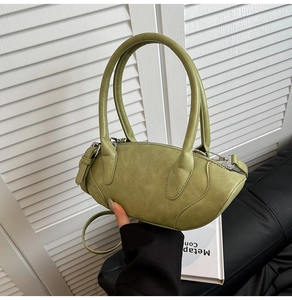 Detail of green faux leather handbag with vintage cloud texture and silver buckle