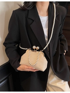 Handwoven beige straw bag with large pearl clasp and pearl beaded shoulder strap
