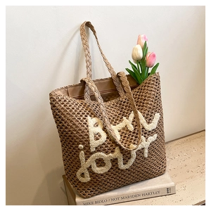 Dettaglio della borsa tote intrecciata con ricamo BY JOUY e decorazione di tulipani